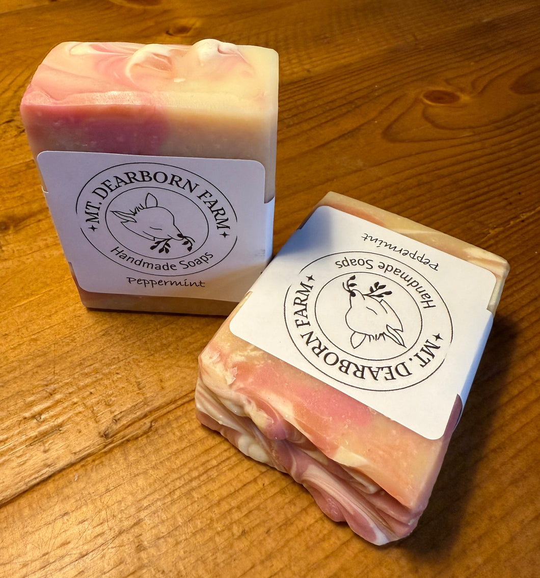 Two soap bars with 'Mt. Dearborn Farm' branding on a wooden surface