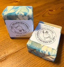 Load image into Gallery viewer, Two goat milk soap bars with &#39;Mt Dearborn Farm branding on a wooden surface